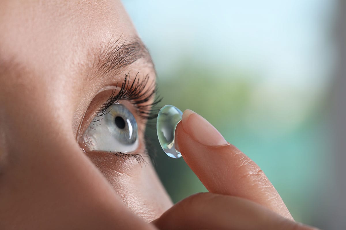 Woman putting in contact lenses